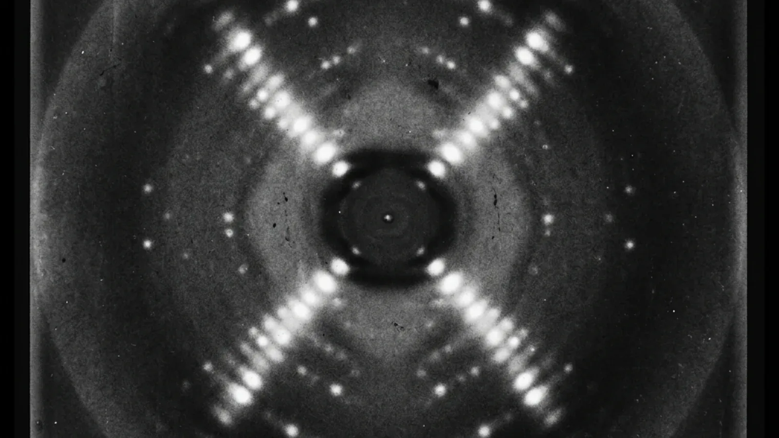 Rosalind Franklin's Photograph 51: an X-ray diffraction image of crystallized DNA fibers showing the characteristic cross-shaped pattern of spots that revealed the double-helix structure