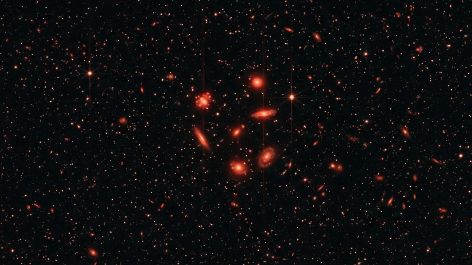 A simulated JWST deep-field image with several very distant galaxies circled showing their unusually red, bright signatures